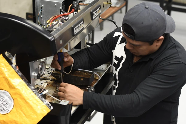 Hombre con una máquina de café abierta para mantenimiento